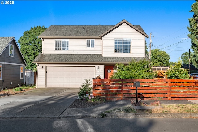 traditional-style home featuring fence, driveway, roof with shingles, and a garage