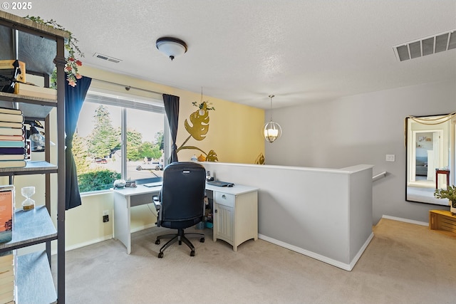 office with light colored carpet, a textured ceiling, and visible vents