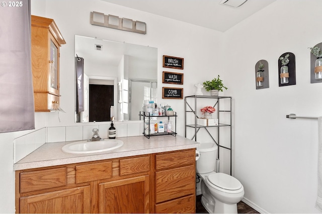 bathroom with toilet, visible vents, and vanity