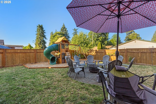 view of yard featuring a playground, a fire pit, and a fenced backyard