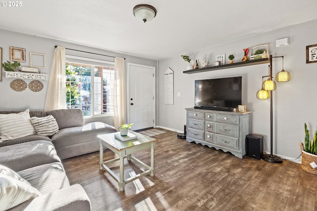living area with baseboards and dark wood finished floors