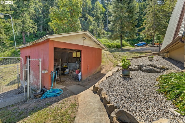 331 Hemlock Ln, Roseburg, OR 97471 - view of outdoor structure with fence, a forest view, and an outbuilding