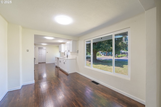 562 Gatch St, Woodburn, OR 97071 - empty room with a sink, dark wood-style floors, baseboards, and a textured ceiling