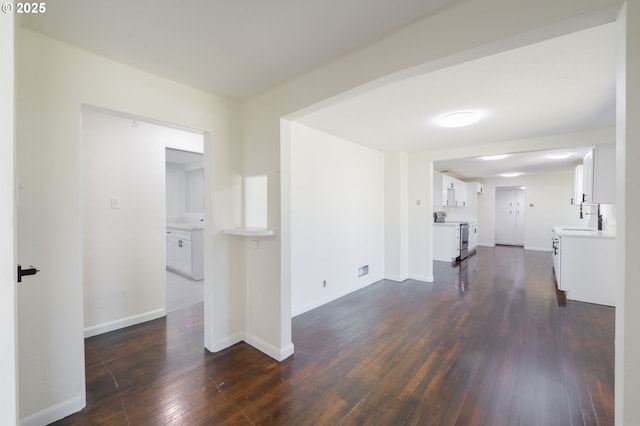 562 Gatch St, Woodburn, OR 97071 - unfurnished living room featuring dark wood-style floors, a sink, and baseboards