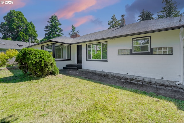 562 Gatch St, Woodburn, OR 97071 - view of front of property with a front yard, a chimney, concrete block siding, and a shingled roof