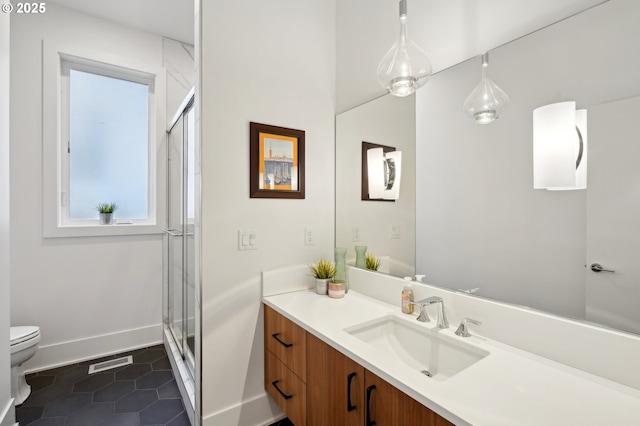 bathroom with toilet, tile patterned flooring, vanity, a shower stall, and baseboards