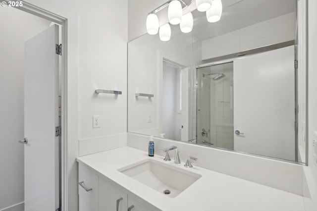 full bath featuring a shower with shower door and vanity