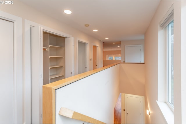 corridor featuring an upstairs landing and recessed lighting