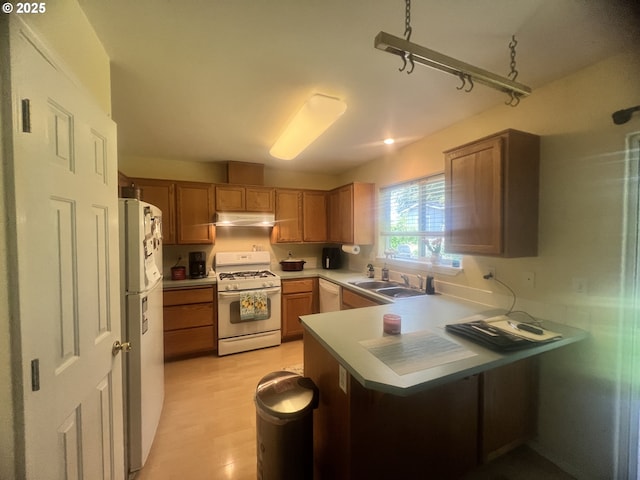 4733 Spring Meadow Ave, Eugene, OR 97404 - kitchen featuring white appliances, under cabinet range hood, a peninsula, light countertops, and brown cabinets