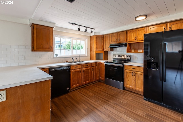 127 Roan Dr, Eugene, OR 97401 - kitchen with black appliances, a sink, under cabinet range hood, brown cabinetry, and tasteful backsplash