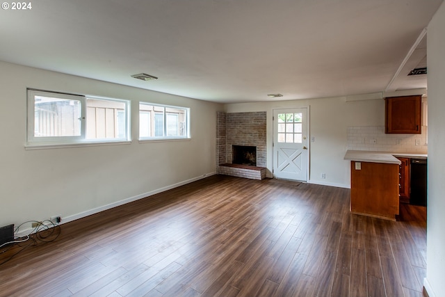 127 Roan Dr, Eugene, OR 97401 - unfurnished living room with a brick fireplace, baseboards, and dark wood-type flooring