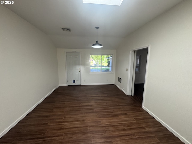 127 Roan Dr, Eugene, OR 97401 - empty room with vaulted ceiling, baseboards, dark wood-style flooring, and a skylight