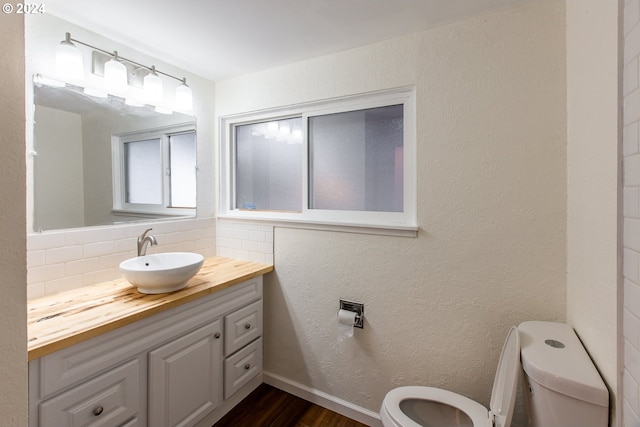 127 Roan Dr, Eugene, OR 97401 - bathroom featuring toilet, wood finished floors, decorative backsplash, and vanity
