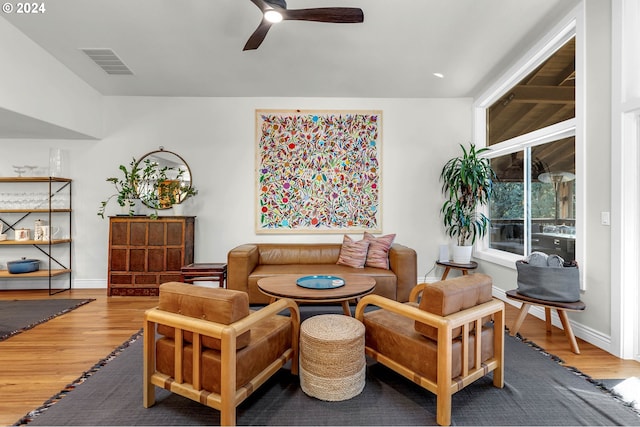 living area with visible vents, baseboards, wood finished floors, and a ceiling fan