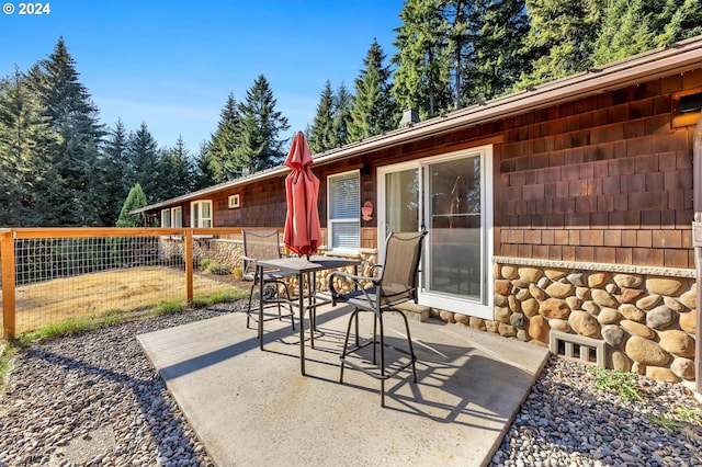 view of patio with outdoor dining area and fence