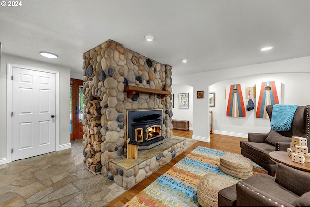 living area with wood finished floors, recessed lighting, baseboards, and arched walkways