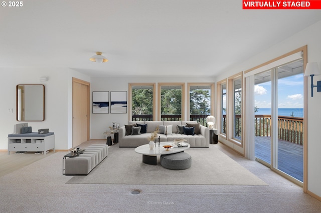 213 University Ave, Manzanita, OR 97130 - living room featuring a water view, baseboards, and carpet floors