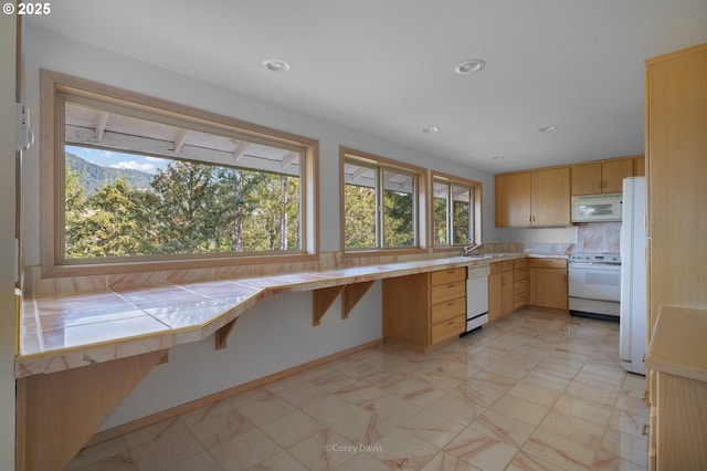 213 University Ave, Manzanita, OR 97130 - kitchen featuring white appliances, recessed lighting, marble finish floor, decorative backsplash, and tile counters