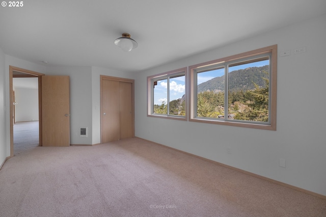 213 University Ave, Manzanita, OR 97130 - unfurnished bedroom with a mountain view, a closet, baseboards, and carpet