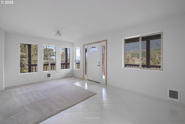 213 University Ave, Manzanita, OR 97130 - tiled foyer entrance with visible vents, baseboards, and a healthy amount of sunlight