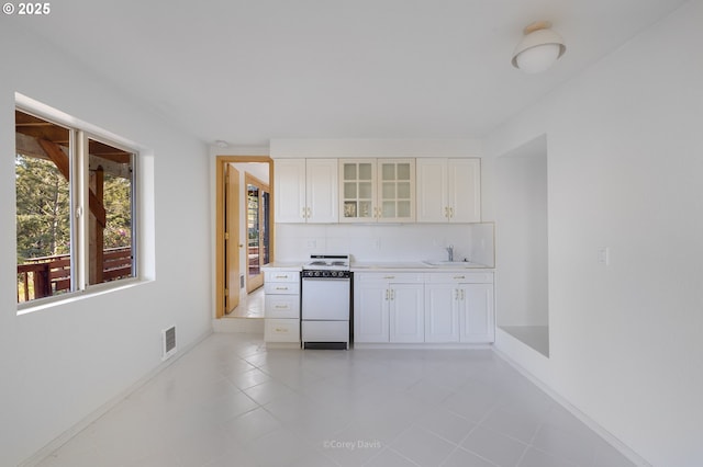 213 University Ave, Manzanita, OR 97130 - kitchen featuring white range, a sink, visible vents, and a healthy amount of sunlight