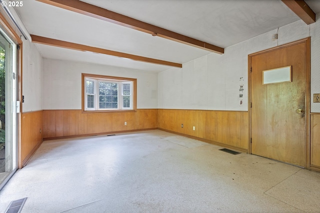 entrance foyer featuring wainscoting, plenty of natural light, beamed ceiling, and wooden walls
