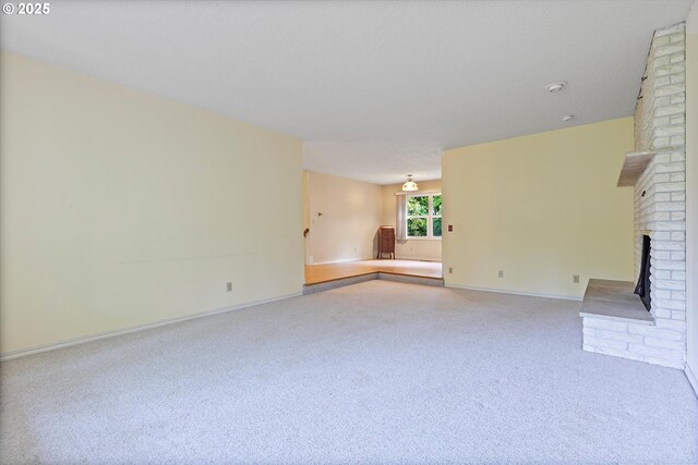 unfurnished living room with a fireplace, carpet flooring, and baseboards