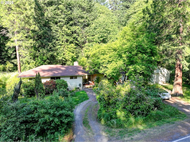 6620 SE Barbara Welch Rd, Portland, OR 97236 - view of front of house featuring a view of trees, a chimney, and dirt driveway