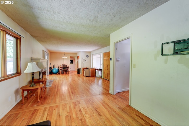 6620 SE Barbara Welch Rd, Portland, OR 97236 - living area with a textured ceiling, light wood-type flooring, and a chandelier