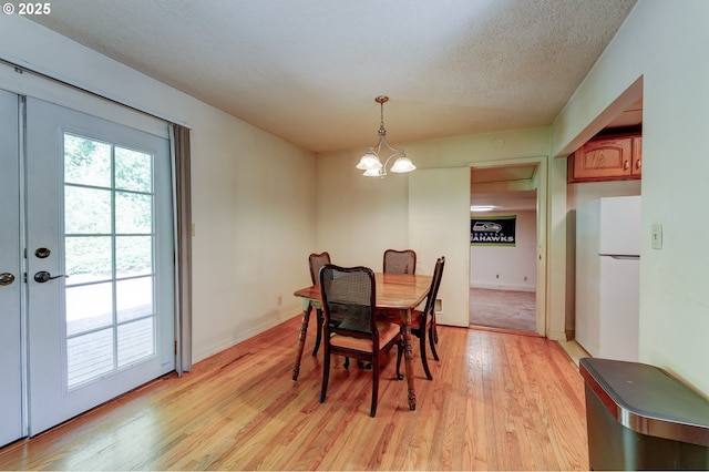 6620 SE Barbara Welch Rd, Portland, OR 97236 - dining room featuring light wood-style floors, a chandelier, and a textured ceiling