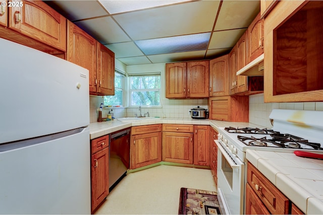 6620 SE Barbara Welch Rd, Portland, OR 97236 - kitchen featuring white appliances, under cabinet range hood, tile countertops, backsplash, and a drop ceiling