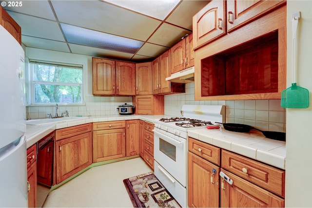 6620 SE Barbara Welch Rd, Portland, OR 97236 - kitchen featuring white appliances, under cabinet range hood, tasteful backsplash, and tile counters