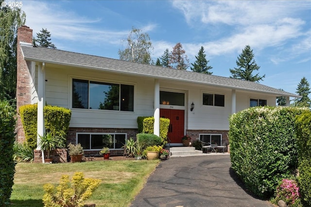 1941 NE 143rd Ave, Portland, OR 97230 - split foyer home with brick siding, a chimney, and a front yard