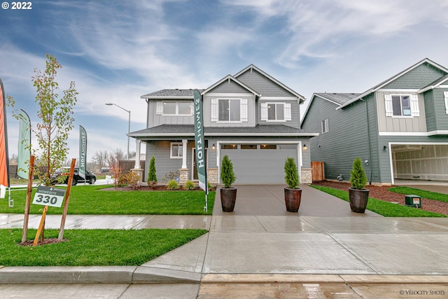 view of front of home featuring concrete driveway, board and batten siding, an attached garage, and a front yard