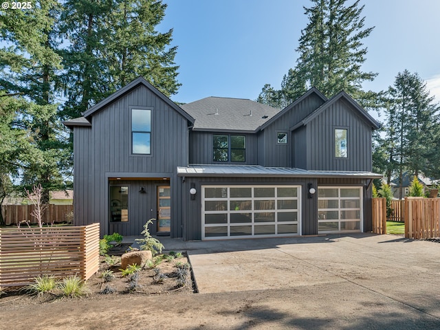 modern farmhouse featuring fence, board and batten siding, and driveway