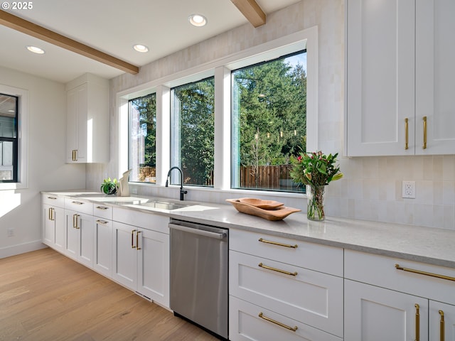 kitchen with beamed ceiling, light wood-style flooring, a sink, stainless steel dishwasher, and white cabinetry