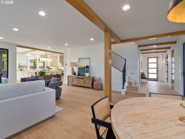 dining space with light wood finished floors, beam ceiling, recessed lighting, and stairs