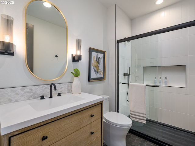 bathroom with a shower stall, toilet, and vanity