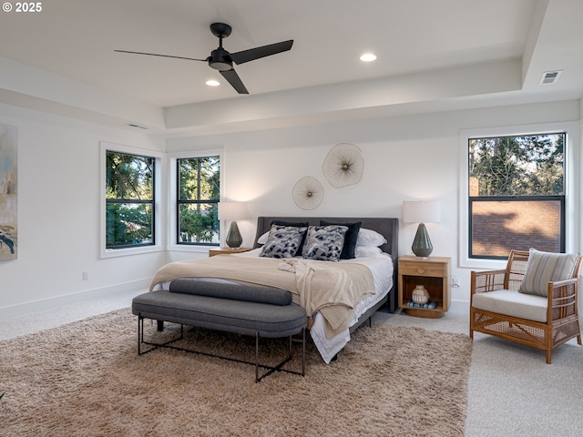 carpeted bedroom featuring visible vents, recessed lighting, a raised ceiling, and baseboards