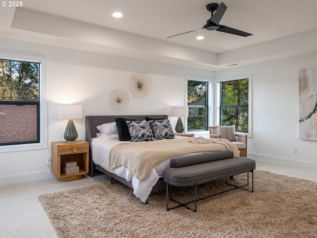 carpeted bedroom with visible vents, recessed lighting, a raised ceiling, and baseboards