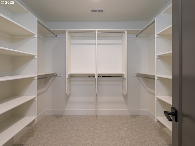 walk in closet featuring visible vents and carpet