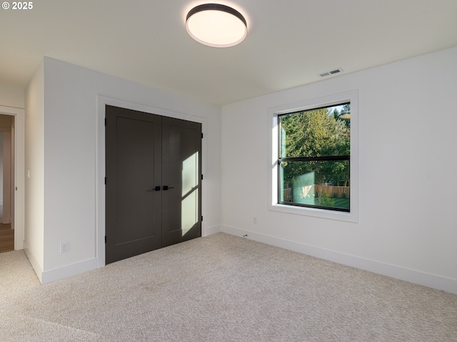 empty room with visible vents, carpet floors, and baseboards