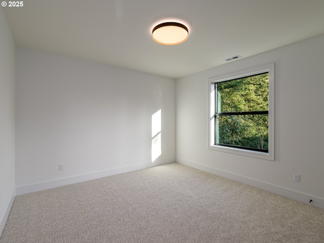 spare room with visible vents, baseboards, and carpet floors