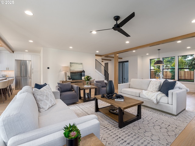 living room with stairway, light wood finished floors, recessed lighting, ceiling fan, and beamed ceiling