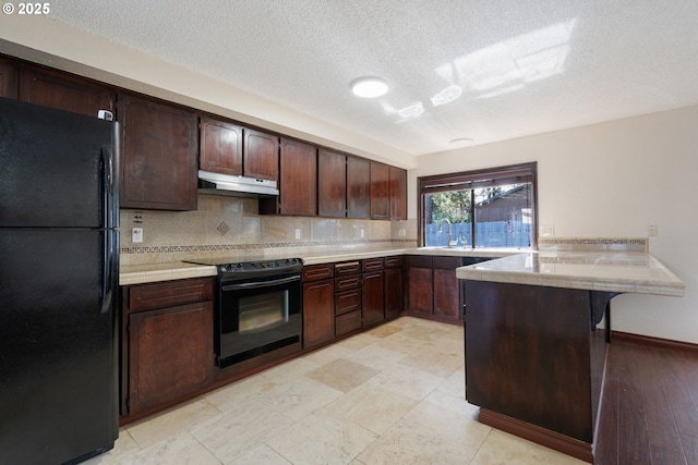 kitchen with under cabinet range hood, backsplash, black appliances, and a peninsula