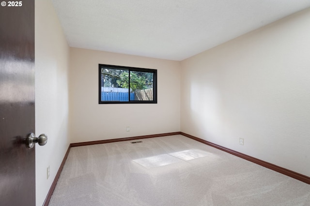 empty room with visible vents, baseboards, and carpet floors