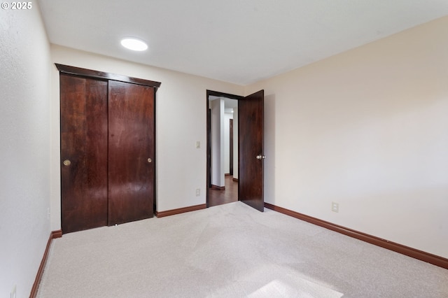 unfurnished bedroom featuring a closet, baseboards, and carpet