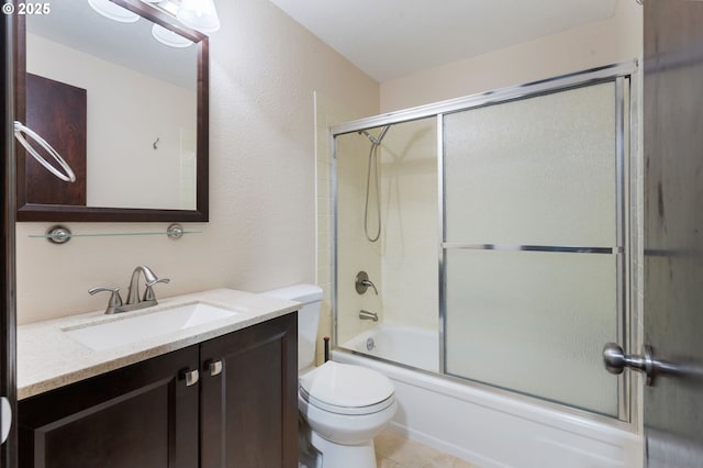 bathroom featuring combined bath / shower with glass door, toilet, and vanity