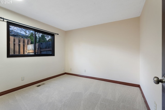 carpeted empty room with visible vents and baseboards