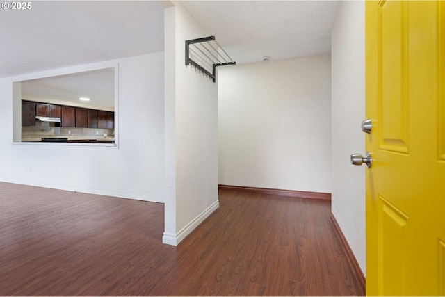 interior space featuring baseboards and dark wood-style floors